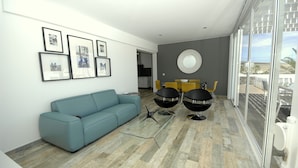 Una sala moderna con un sofá azul, una mesa de centro de vidrio y un comedor con sillas amarillas.