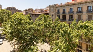Un immeuble à plusieurs étages, doté de balcons et présentant un mélange de styles architecturaux, notamment une tour en pierre.