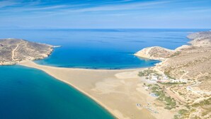 An aerial view of a coastal area with a sandy beach, a small island, and a clear blue sea. - Prasonisi Villas (Rhodes)