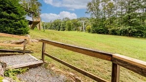 Une terrasse en bois offrant une vue sur un champ verdoyant et des arbres.