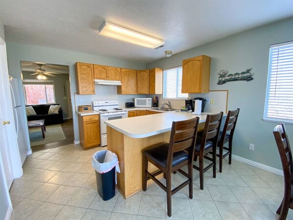 A kitchen with wooden cabinets, a central island, a microwave, and a sink.