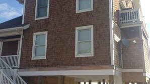 A two-story building with a balcony on the second floor. - Beautiful 5-bedroom 5-bathroom home on the Beach at the Jersey Shore (Point Pleasant Beach)