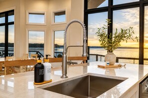 A modern kitchen with a stainless steel sink, a faucet, and a vase with greenery. - 🔥Luxe Lakefront Escape! HEATED Pool🌊Hot Tub✨Stunning Sunrise🌅8BR+Guest House! (Littleton)