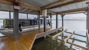 A boat docked at a pier with a wooden deck and a metal roof.