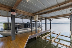 A boat docked at a pier with a wooden deck and a metal roof.