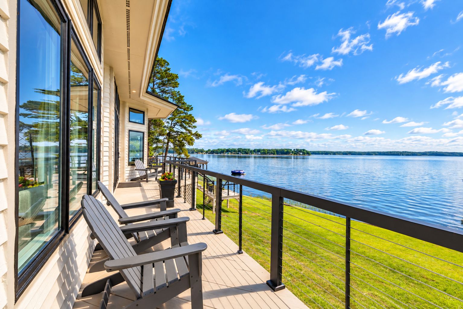 A deck with outdoor seating and a view of a lake.