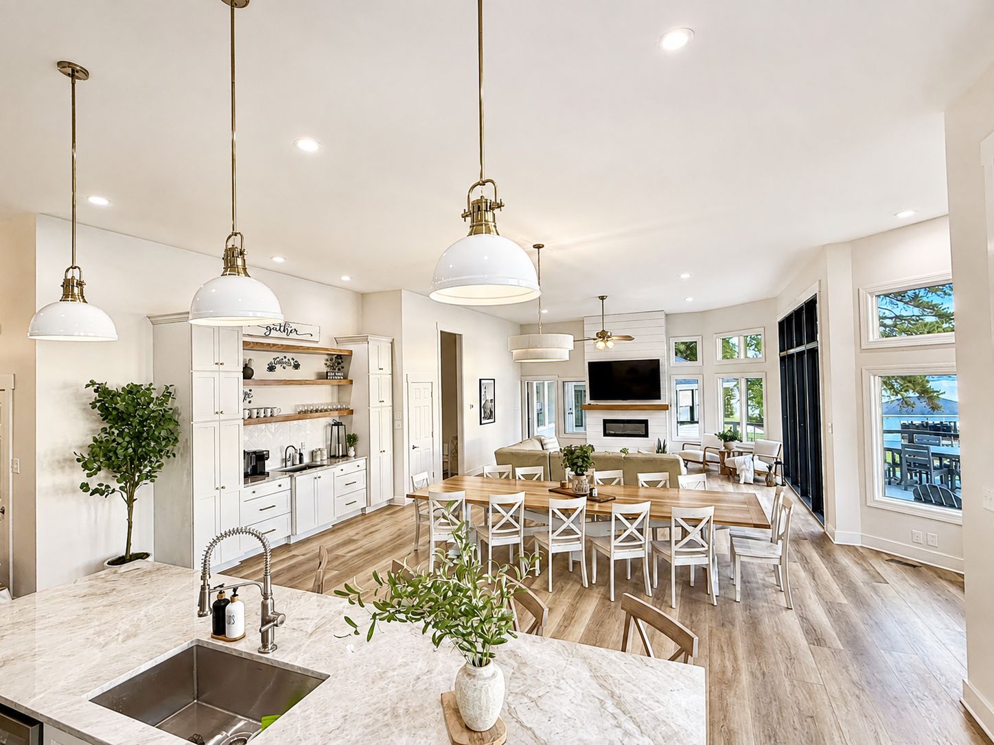 A spacious kitchen with a central island, pendant lighting, and a large window providing natural light.