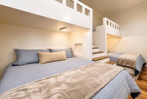 Ein Schlafzimmer mit zwei Betten, einer Treppe und einer Lampe.