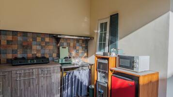A compact kitchen with a gas stove, a microwave, and a small refrigerator.