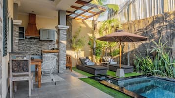 Zona exterior privada amb piscina, gandules i menjador.