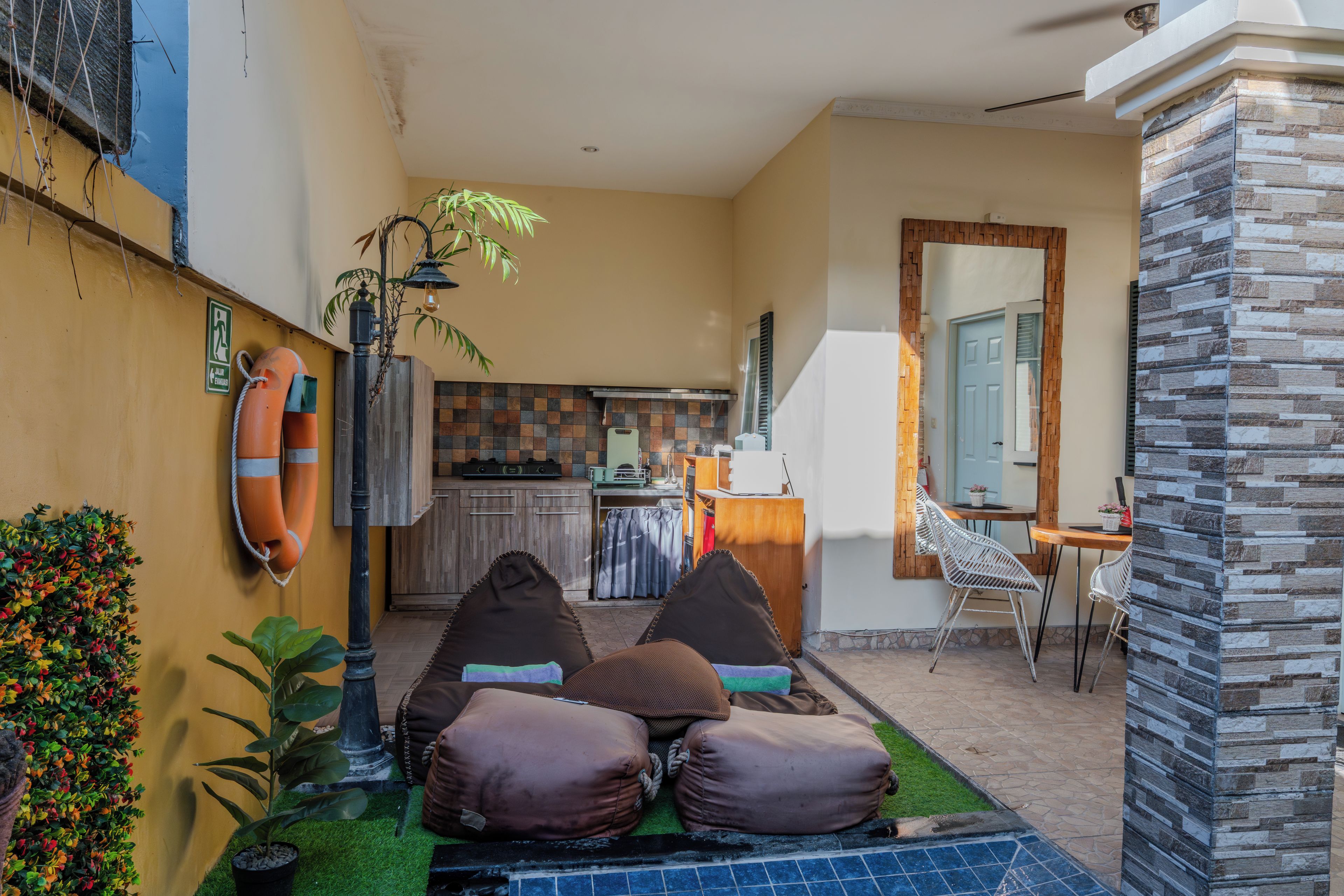 A compact living space with a kitchenette, a dining area, and a seating area with cushions.