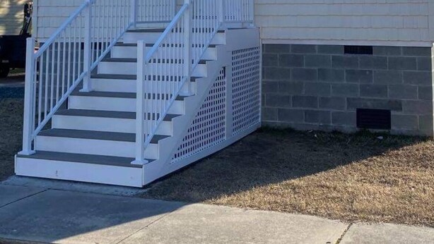 A two-story house with a front porch, a staircase, and a garage. - Cottage On Famous Chincoteague Island-Famous Wild Ponies (Chincoteague Island)