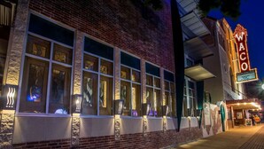 Un bâtiment en briques doté de grandes fenêtres et d’une enseigne lumineuse au néon indiquant « WACO ».