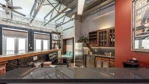 Une cuisine moderne dotée d’un grand îlot central, d’un réfrigérateur et d’armoires en bois.