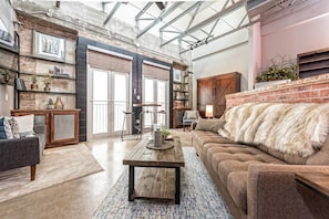 Relax in this stylish living area with a plush sofa, wooden coffee table, and comfortable seating options.