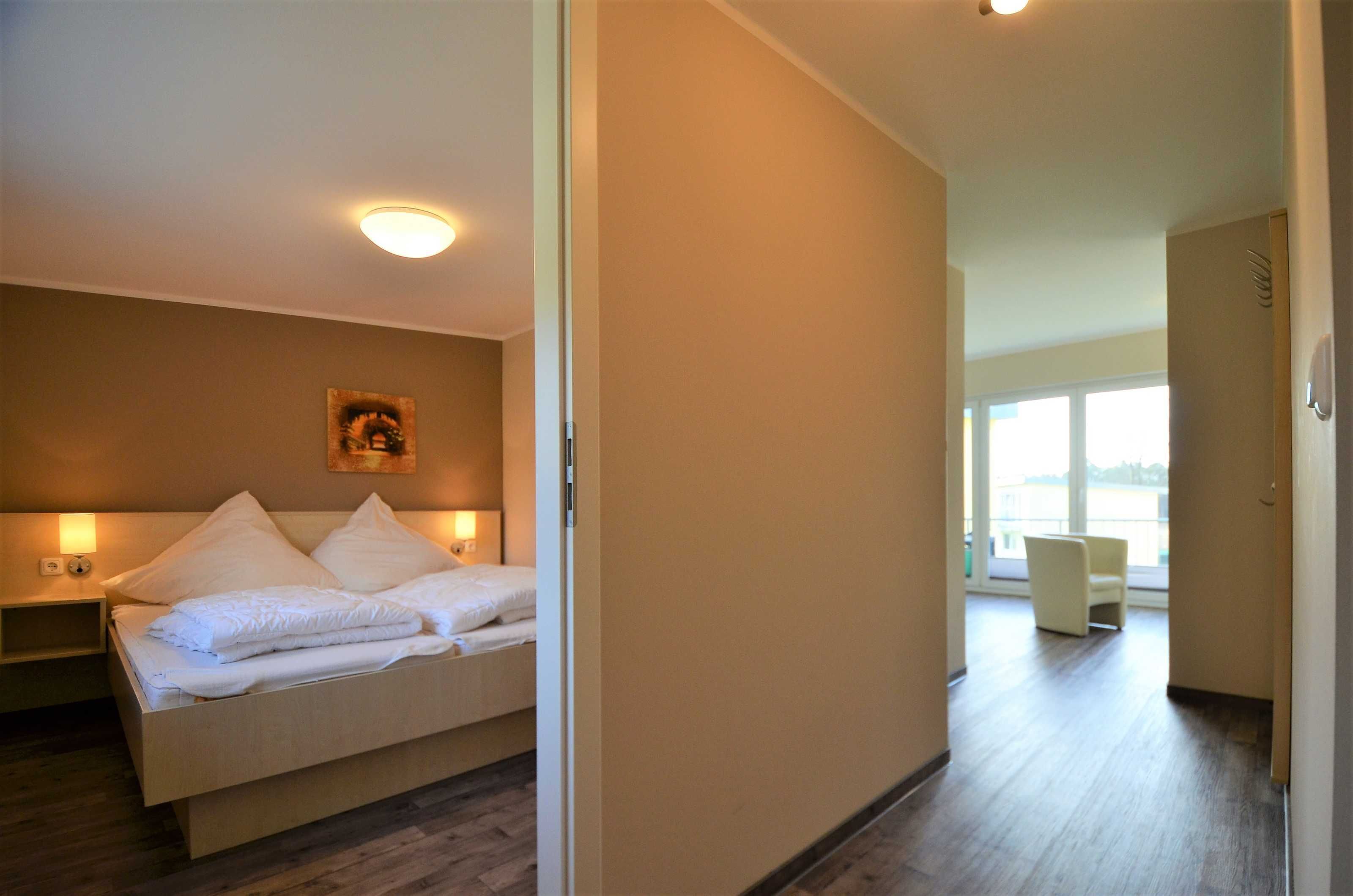 Ein Hotelzimmer mit Bett, Nachttisch und einem Bild an der Wand.
