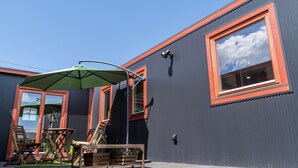 A modern building with a large window and a green umbrella. - Phottage inn Biei (Biei)