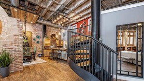 Une cuisine spacieuse avec un mur en briques, un plancher en bois et un coin bar moderne.