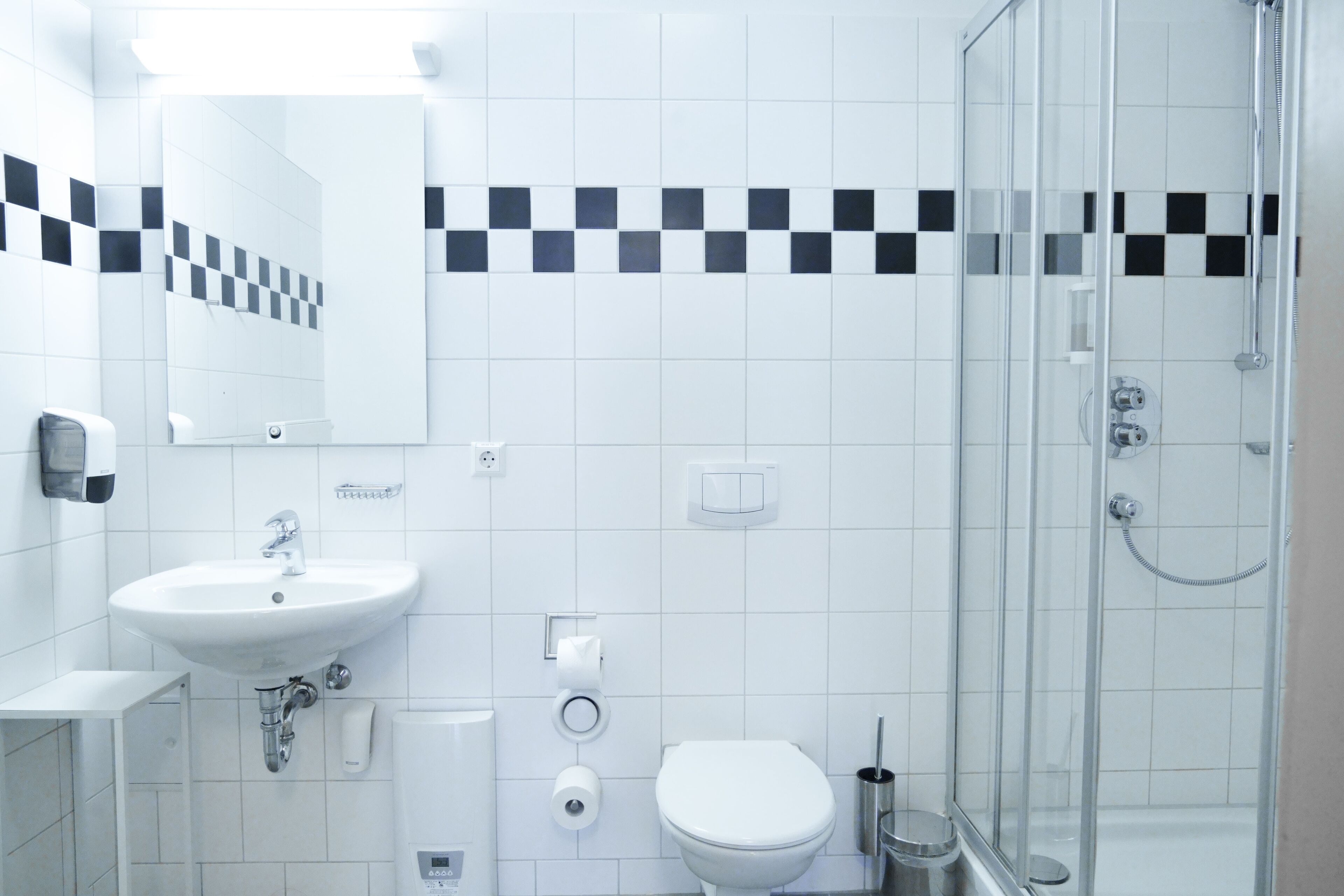 A modern bathroom with a sink, toilet, and glass-enclosed shower.