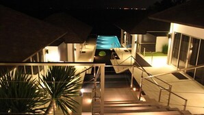 Et poolområde med en trappe, der fører op til en overdækket terrasse.