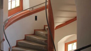 A spiral staircase with wooden steps and metal railings, leading to an upper floor. - Double room - Cranach hostel Wittenberg (Lutherstadt Wittenberg)