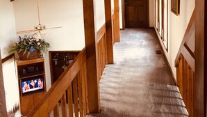 A wooden staircase with a carpeted floor leading to a door at the end.