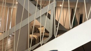 A staircase with rope barriers and a shark decoration on the railing.
