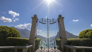A wrought iron gate with a clear view of a mountainous landscape through it. - Sunrise House with Balcony and Parking, Lugano, Switzerland (Lugano)