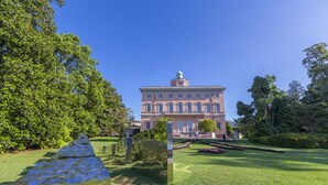 A large building with a central dome and symmetrical windows, surrounded by well-maintained grass and trees. - Sunrise House with Balcony and Parking, Lugano, Switzerland (Lugano)