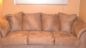Un canapé en cuir marron avec un coussin et un plancher en bois.