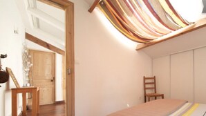 A bedroom with a bed, a chair, a wooden desk, and a slanted ceiling. - Montpellier center cozy house (Montpellier)