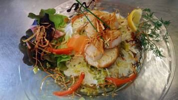 A plate of food with various vegetables and a lemon wedge.