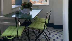 Un comedor con mesa y sillas, vista al mar y una torre del reloj al fondo.