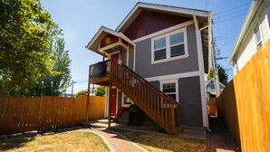 A two-story house with a wooden deck and a brick pathway leading to the front door. - DOWNTOWN TACOMA HOUSE OF GRAY #4 (Tacoma)