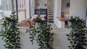 Un salon moderne avec un canapé blanc, une table basse et une plante suspendue.