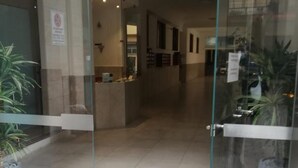 L’entrée d’un hôtel, avec une porte en verre, un comptoir d’accueil et une enseigne portant le numéro 33.