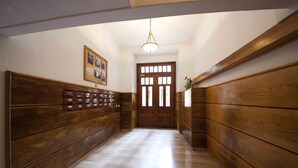 A hallway with wooden paneling, a wooden door, and a framed picture on the wall. - Dream | The Rentals Collection (San Sebastián/Donostia)