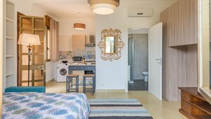 Ein Schlafzimmer mit Bett, Schreibtisch, Waschmaschine und Bad.