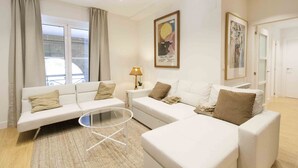 A modern living room with a sofa set, a glass coffee table, and a lamp. - Gallery | The Rentals Collection (San Sebastián/Donostia)