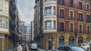 A street view with multi-story buildings, including a building with a 'PO' sign indicating a post office.