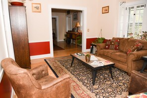 A living room with a brown sofa, a coffee table, and a red and white accent wall.
