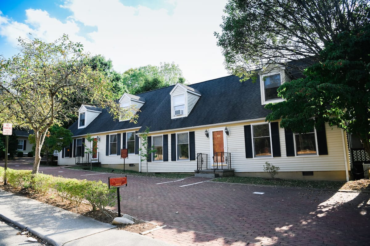 A row of two-story houses with a brick driveway and a sidewalk.