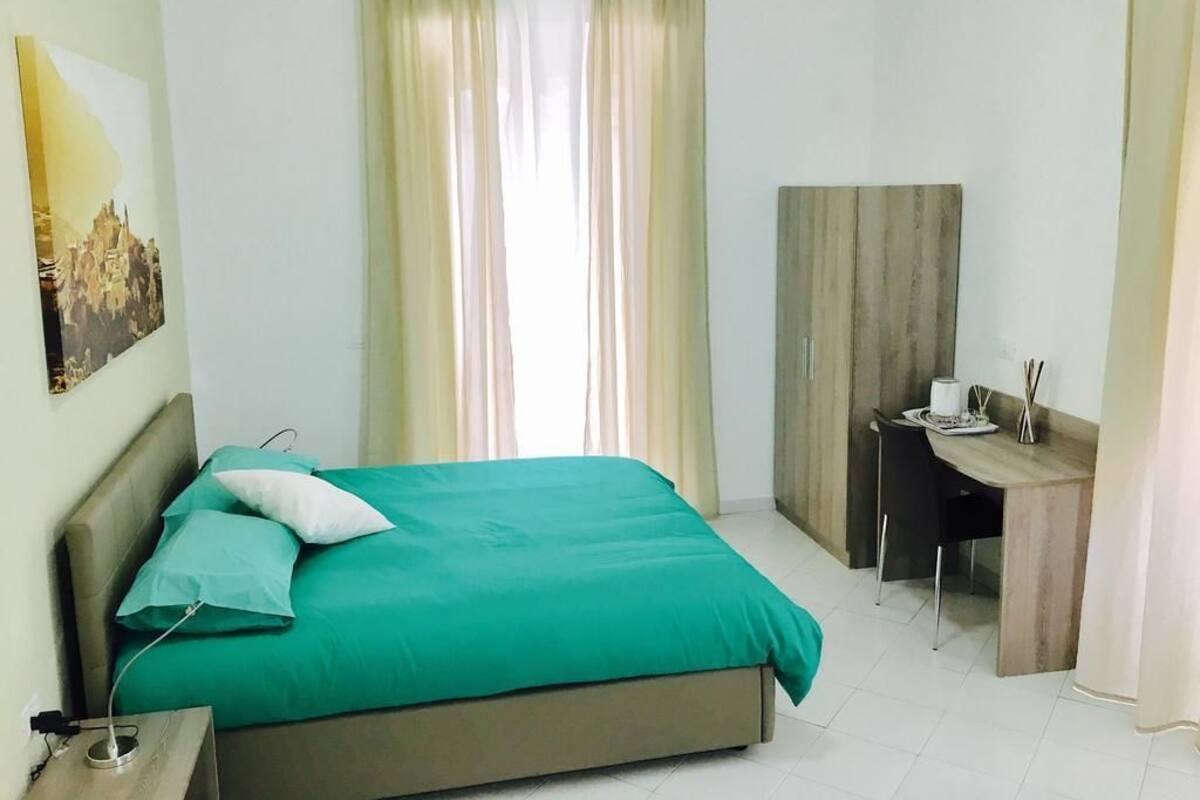 Una habitación de hotel con una cama, un escritorio y una silla.