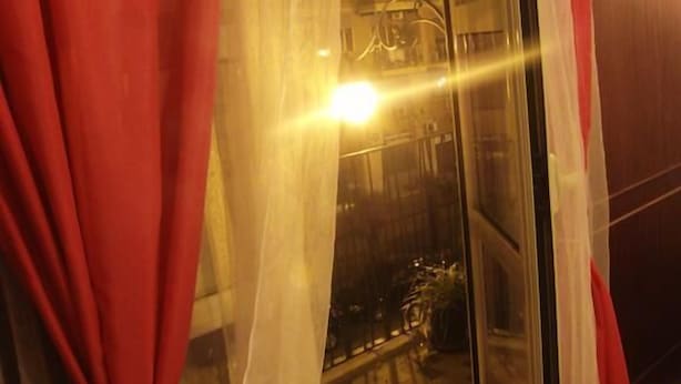 A room with a checkered floor, a glass door, and a red curtain.