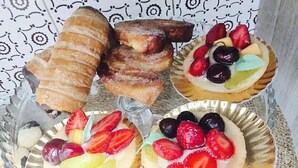 A tray with pastries and fruit-topped desserts.