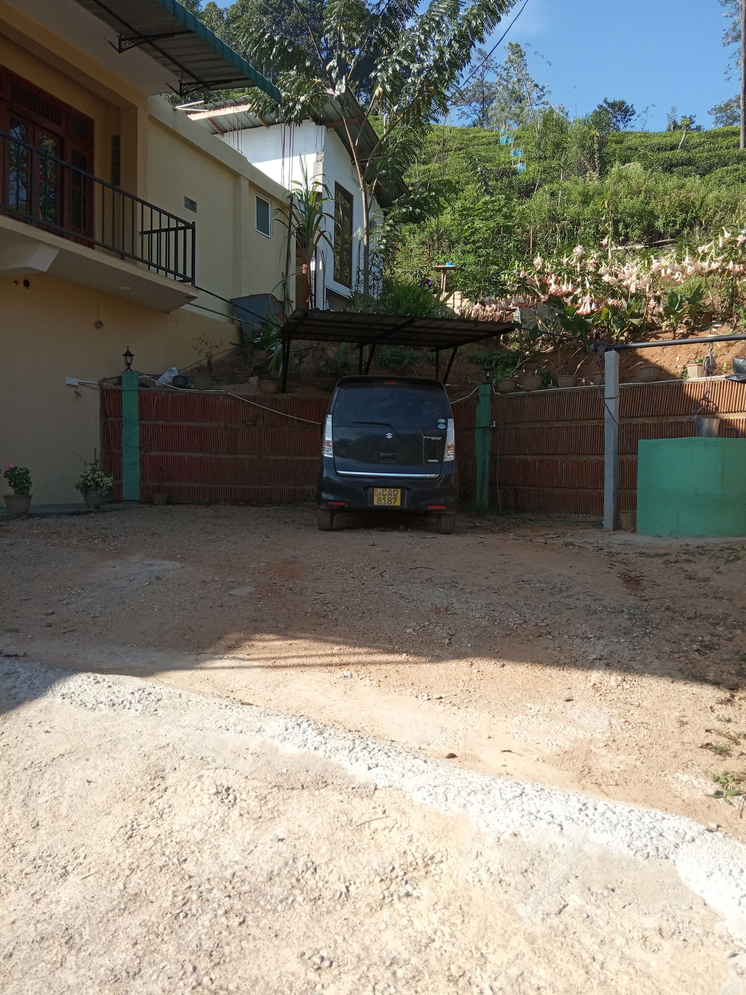 A vehicle parked in a driveway with a house in the background.