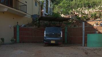 A vehicle parked in a driveway with a house in the background.