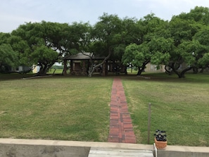 Un sendero de ladrillo que conduce a un pabellón rodeado de árboles.