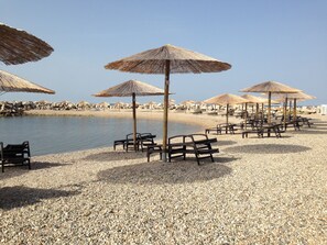 A beach with pebbles, umbrellas, and wooden chairs. - In the historic center just steps from the sea (Novigrad)