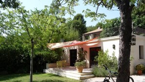A house with a patio, a bicycle, and a tree.
